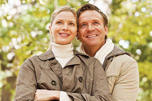 A young couple hold each other while looking at somthing in the distance. A young couple hold each other while looking at somthing in the distance.